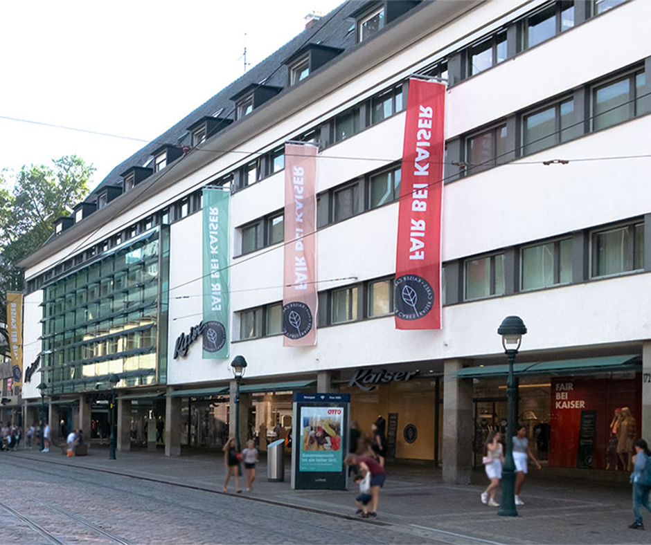 Einkaufsgebäude mit Fahnen und Glasfassade in Freiburg